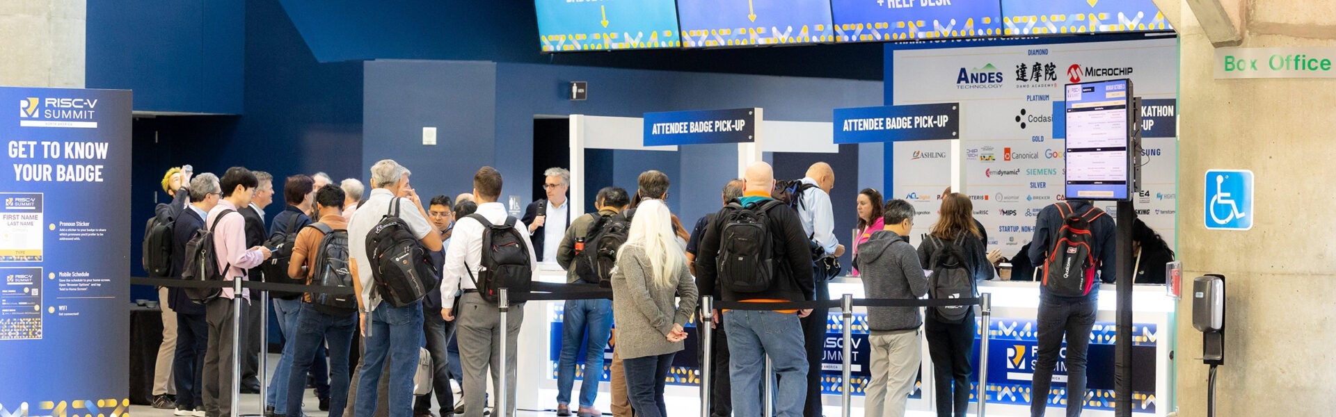 A line of people in front of a registration desk.